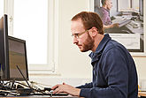 Roman Baum arbeitet am Computer. Er ist Software-Entwickler im Programmbereich Wissensmanagement und Mitglied im Personalrat.